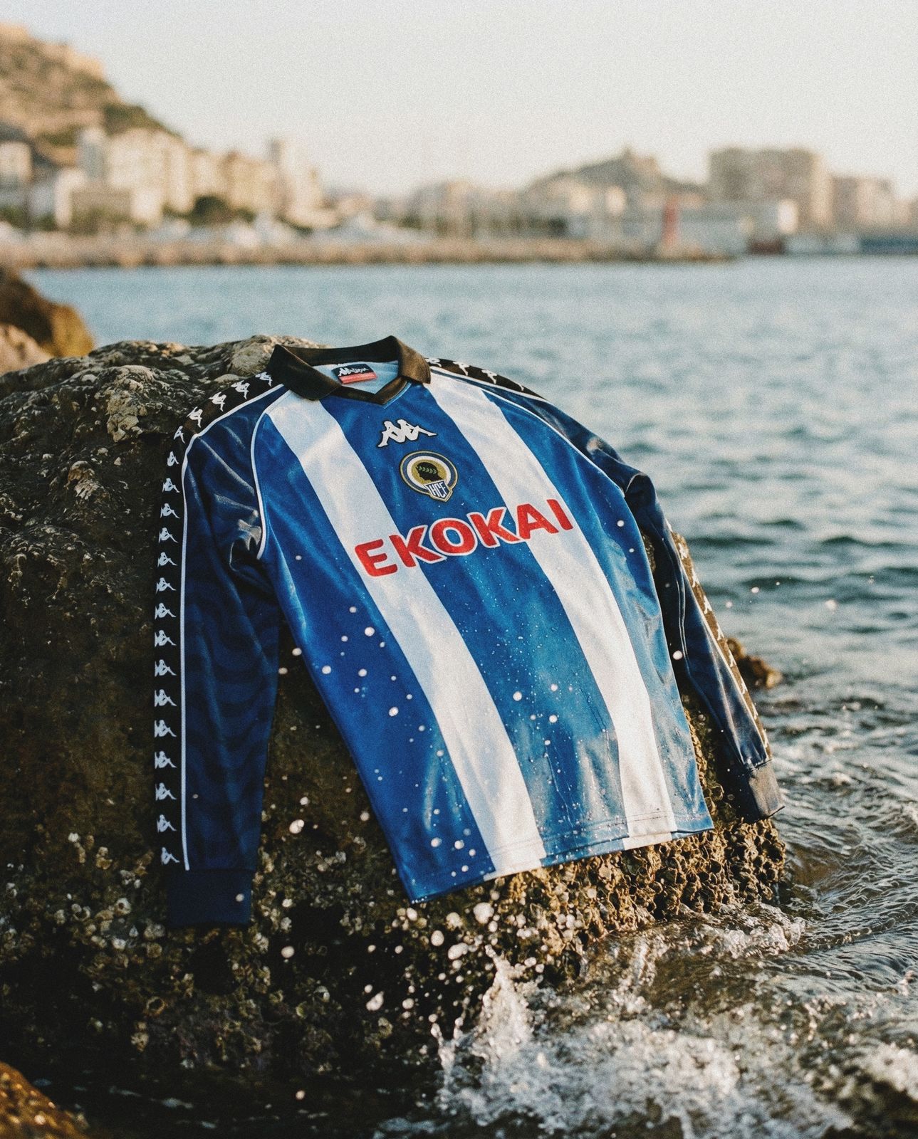 Foto de producto con IA: camiseta de fútbol sobre una roca junto al mar